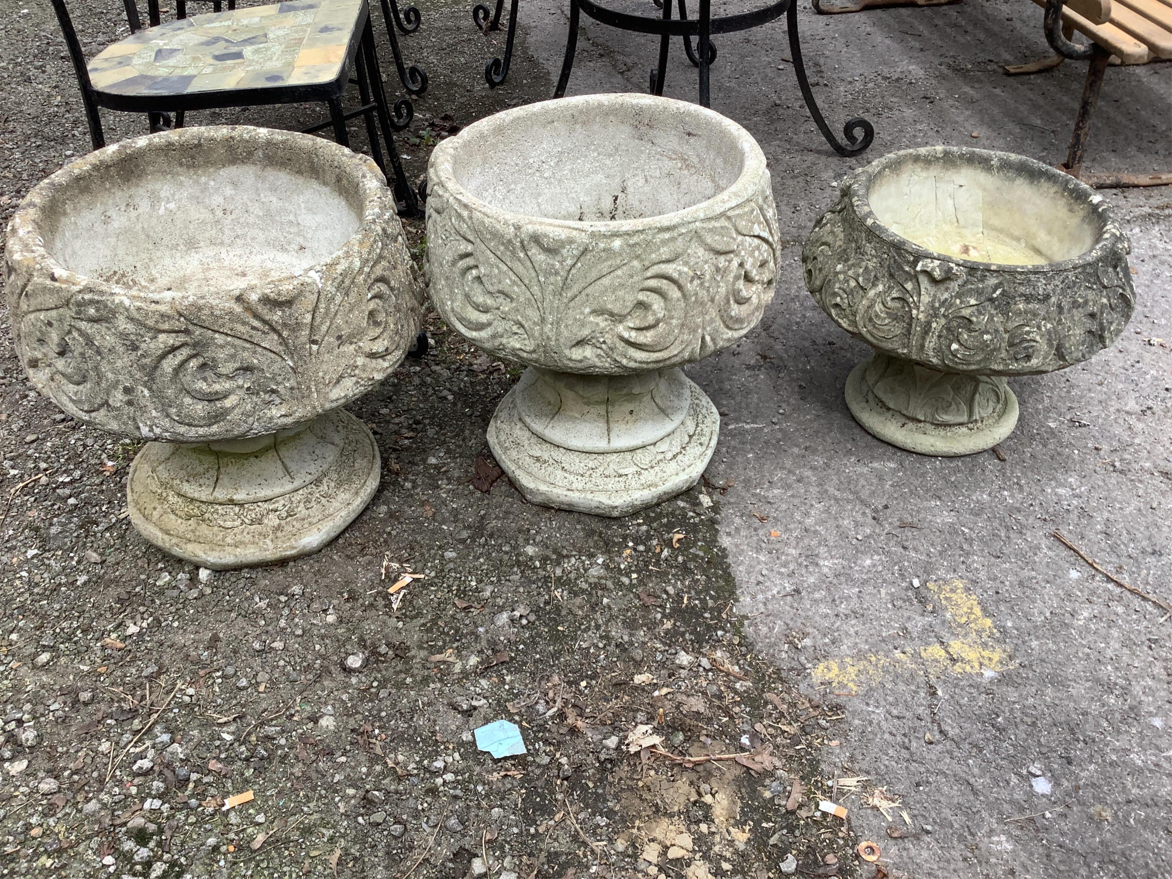 A pair of circular reconstituted stone garden planters, diameter 42cm, height 42cm together with a similar smaller planter